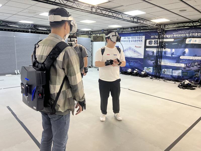 VR훈련에 참여하기 위해서 VR HDM, 가방 콘덴서, 모션캡처 장갑을 착용했다